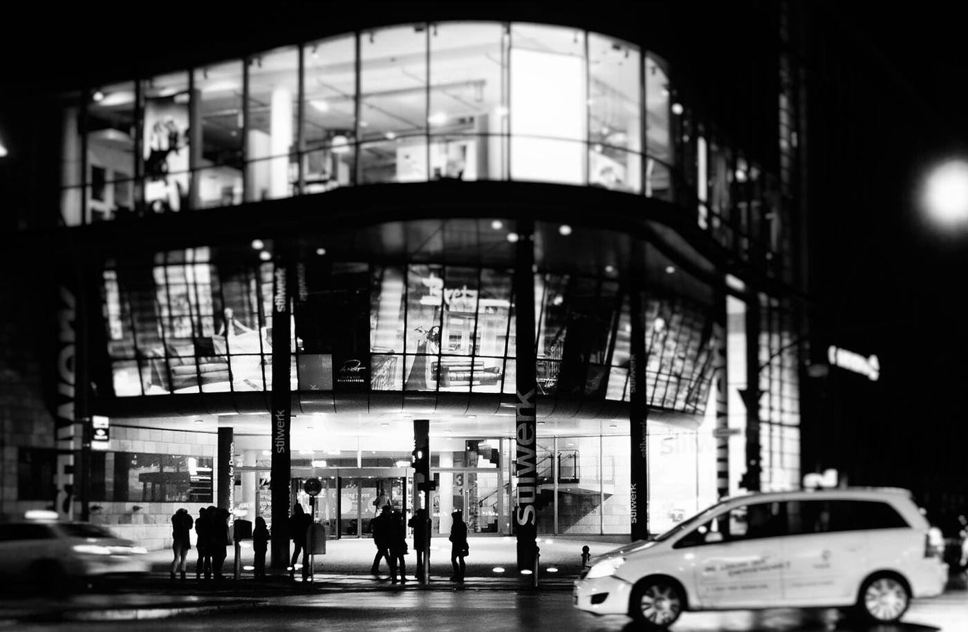Shoppers outside a storefront at night